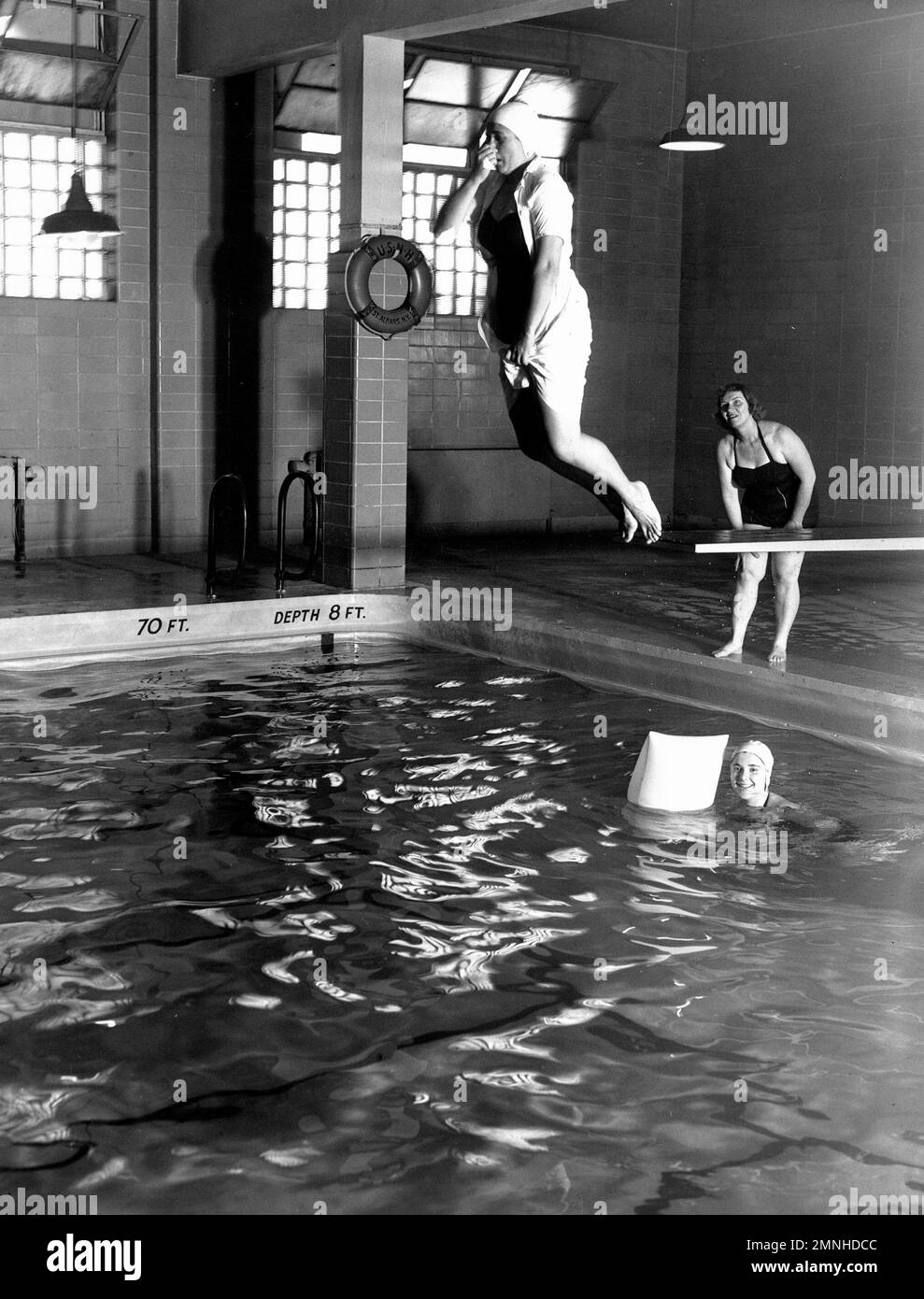 Hôpital naval St. Albans, long Island, New York. La piscine est utilisée à des fins de loisirs et de formation. Ici, une infirmière corps Indoctrinee apprend la plongée en direct du navire de la Croix-Rouge instructeur de natation dans un cours d'après-midi ca. 1958 Banque D'Images