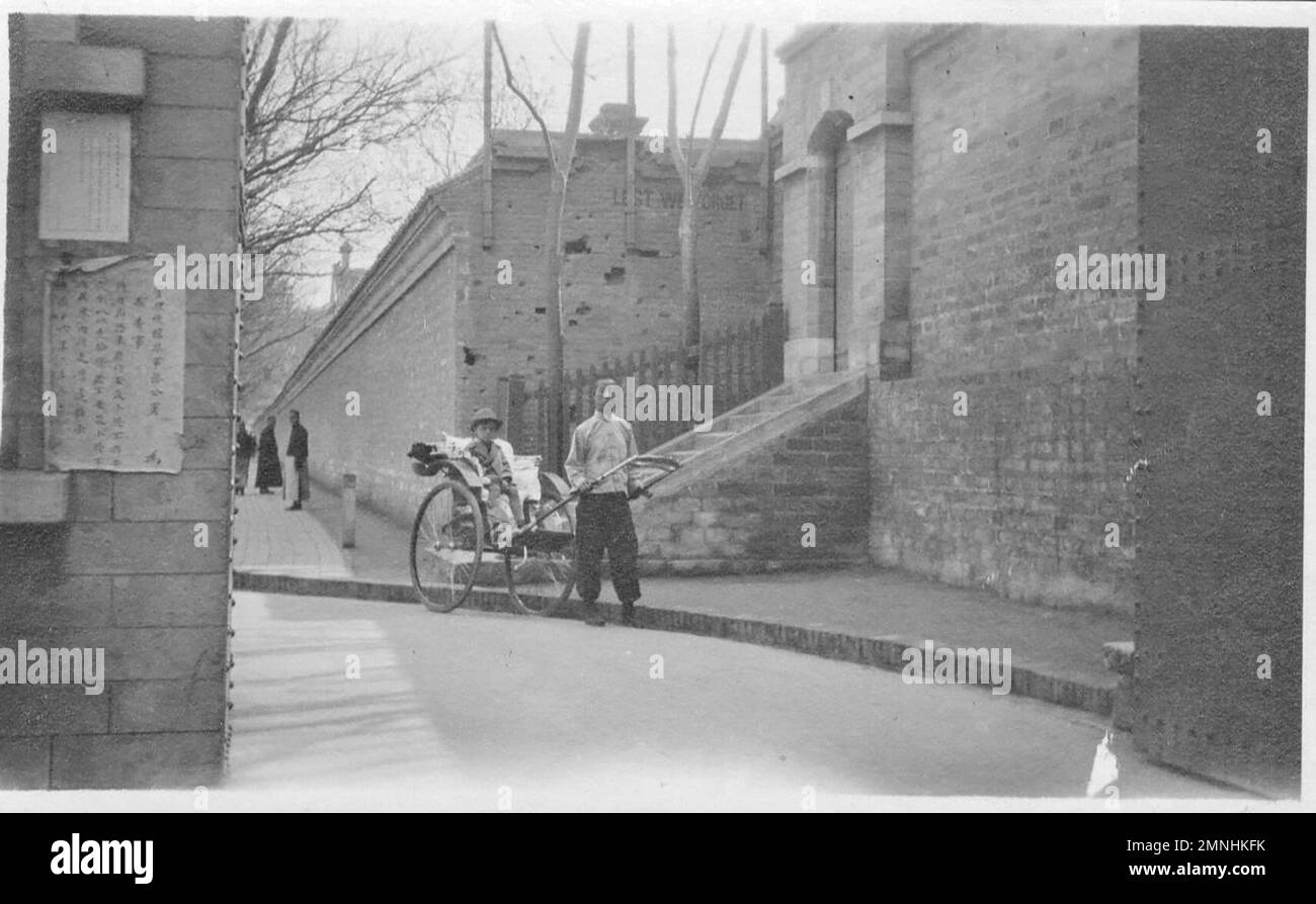 Notez les cicatrices de bataille dans le mur derrière le fils du Dr Lacy - également la légende sur le mur de pierre 'Lest we Forget' - un rappel de la rébellion des boxers, Chine 1927 Banque D'Images