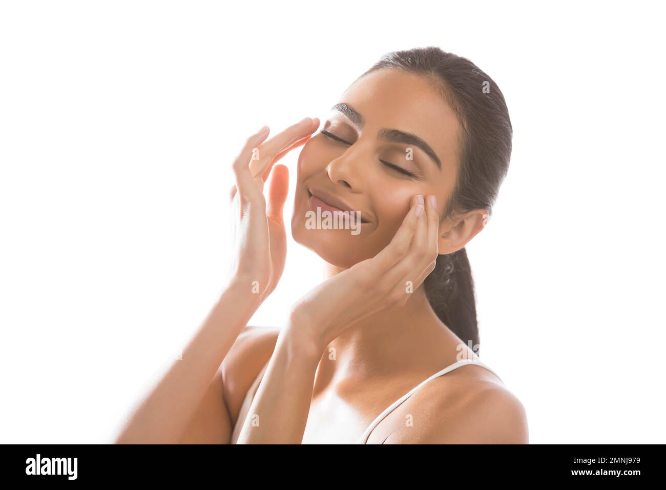 Portrait d'une jeune femme souriante faisant un massage du visage Banque D'Images