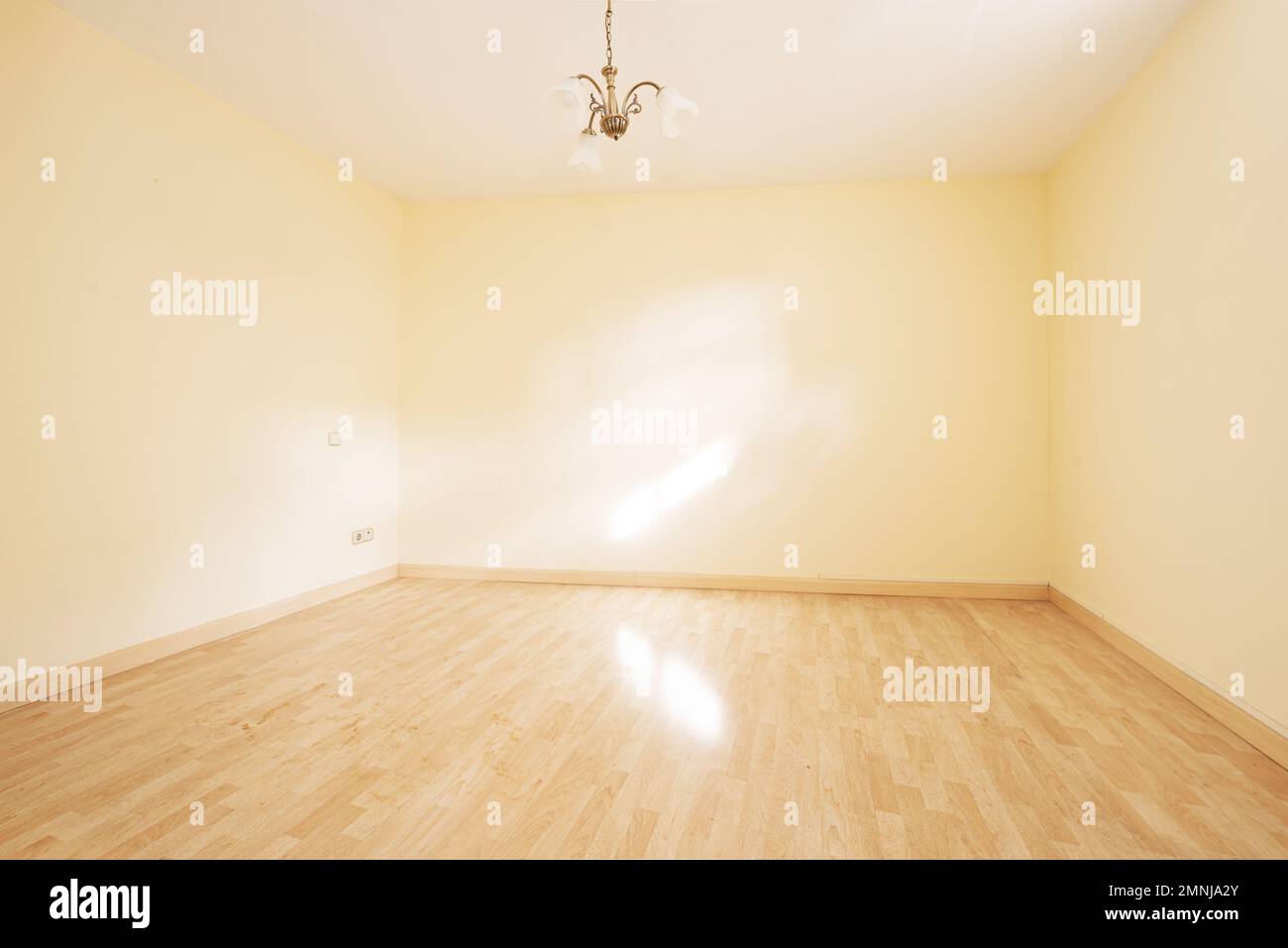 Salle de séjour vide avec murs jaune doux et un abat-jour blanc au plafond Banque D'Images