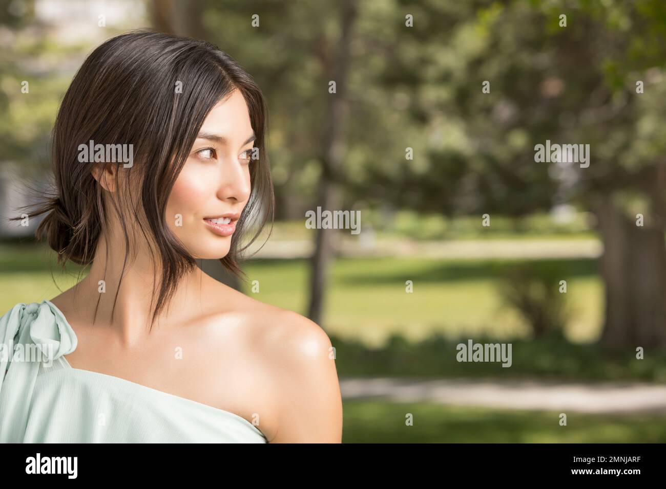 Portrait d'une belle femme qui regarde loin dans le parc Banque D'Images