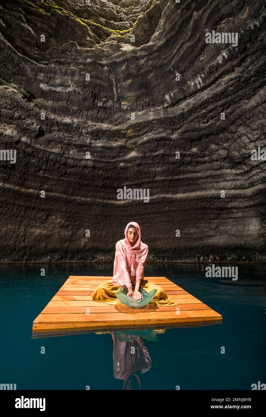 Femme assise sur un radeau en bois au cenote Banque D'Images