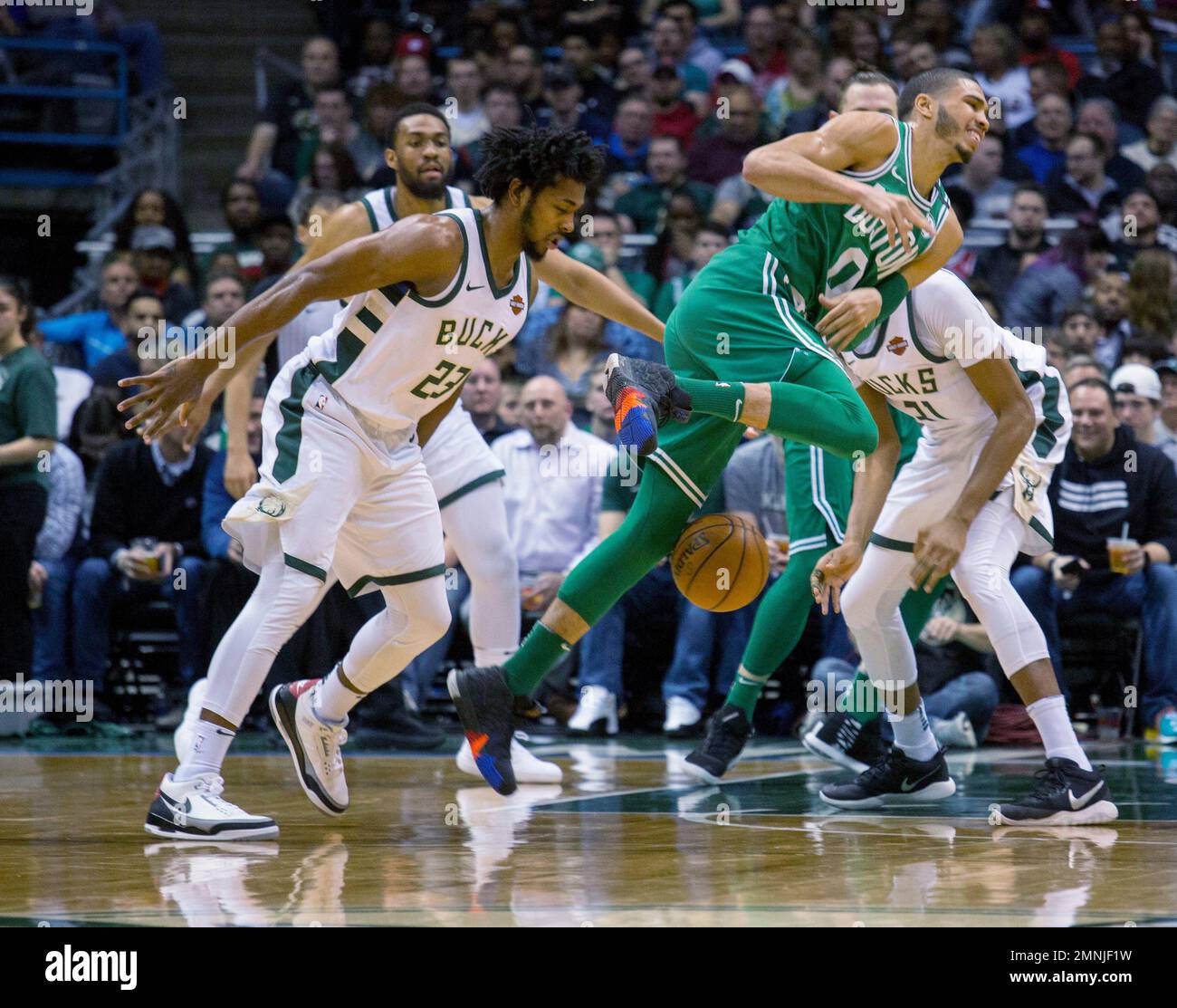 Boston Celtics forward Jayson Tatum, center, is defended by Milwaukee Bucks guard Sterling Brown, left, and John Henson, right, during the first half of an NBA basketball game Tuesday, April 3, 2018, in Milwaukee. (AP Photo/Darren Hauck) Banque D'Images