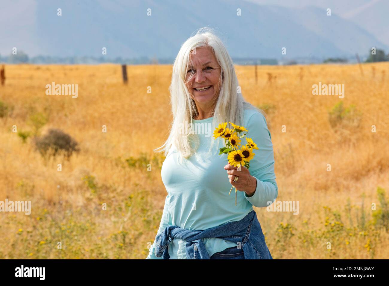 États-Unis, Idaho, Bellevue, Portrait d'une femme âgée tenant un bouquet de tournesols Banque D'Images