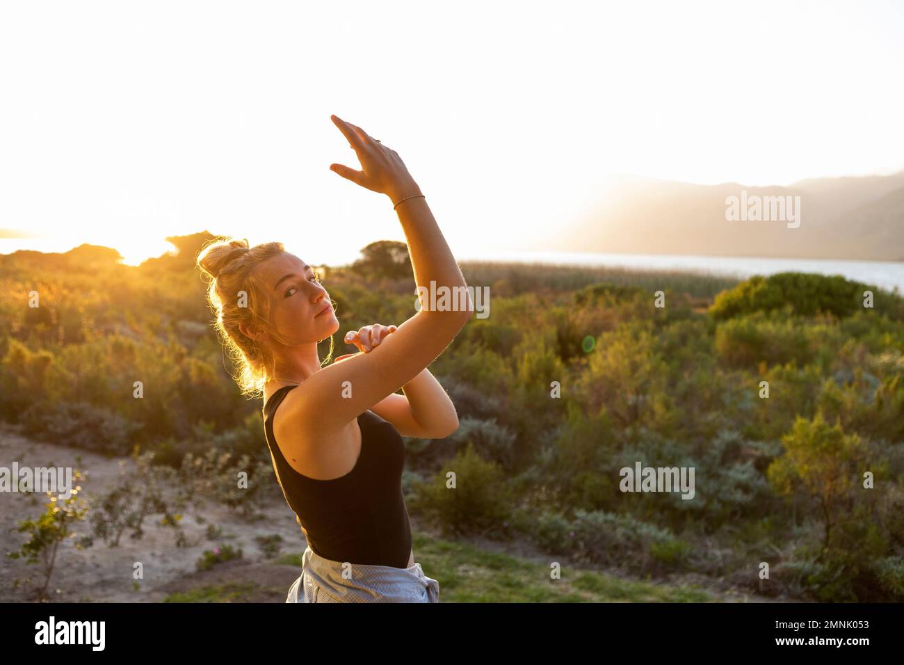 Adolescente (16-17) dansant au coucher du soleil Banque D'Images