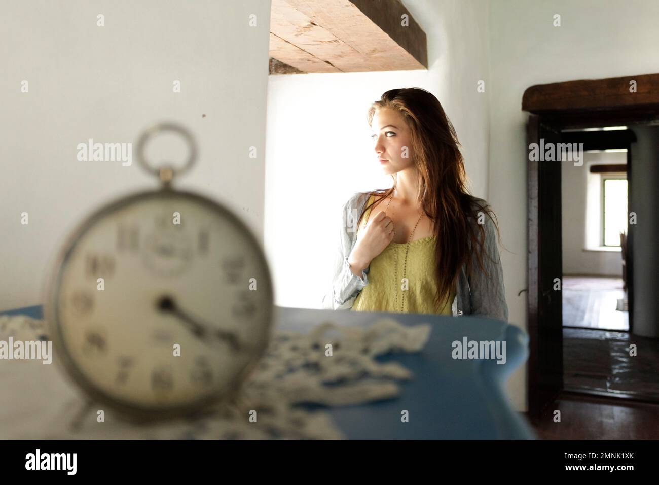 Santa Fe, Nouveau-Mexique, États-Unis. Une jeune femme regarde loin. Horloge vintage. Modèle libéré. Banque D'Images