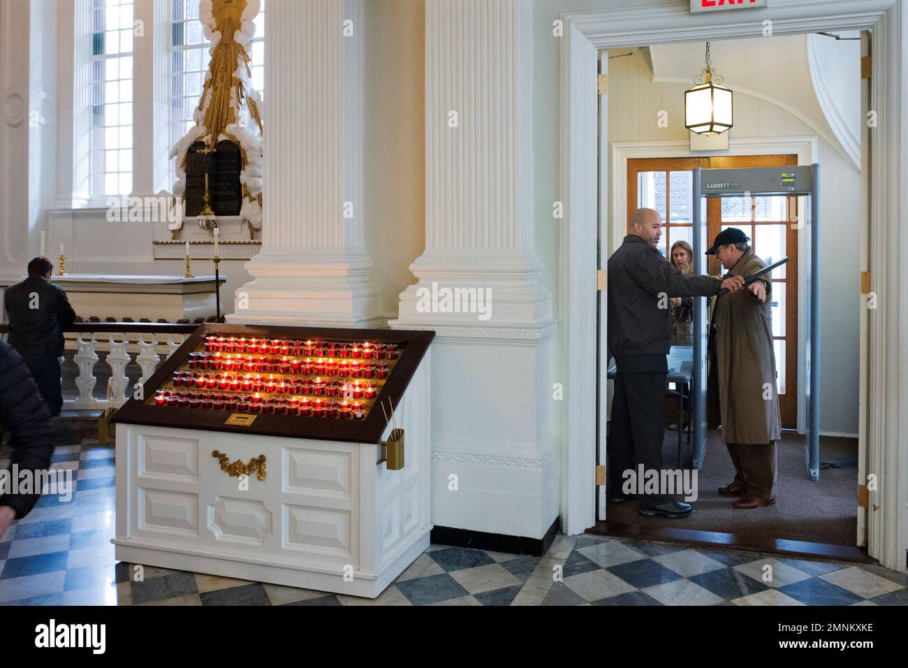 In this March 16, 2018, photo, a security guard checks a visitor at the entrance to St. Paul's Chapel in New York. Two New York City churches that survived the destruction of World Trade Center have become the latest city tourist sites to embrace post-9/11 security measures. Metal detectors were installed for the first time this month at Trinity Church and St. Paul’s Chapel. (AP Photo/Mark Lennihan) Banque D'Images