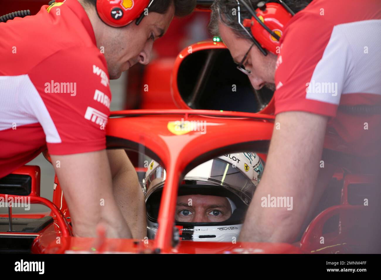 Ferrari driver Sebastian Vettel, bottom, of Germany sits in his car as he prepares to go on the track during the practice session at the Australian Formula One Grand Prix in Melbourne, Saturday, March 24, 2018. The first race of the 2018 seasons is on Sunday. (AP Photo/Rick Rycroft) Banque D'Images
