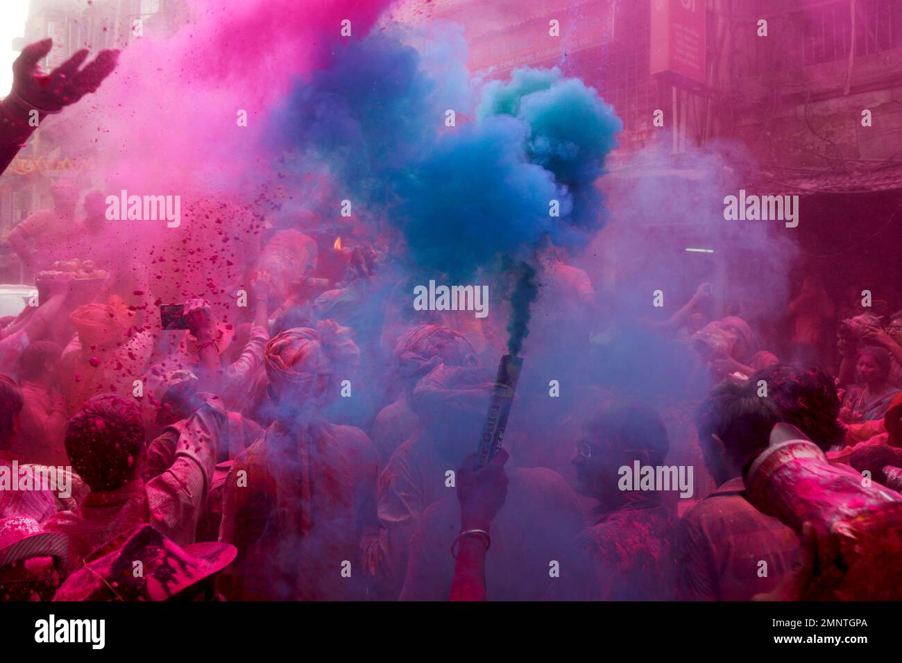 An Indian light up a color smoke candle as a procession of Lord Krishna chariot proceeds through a street celebrating Holi, the Hindu festival of colors, in Kolkata, India, Wednesday, Feb. 28, 2018. The festival also heralds the coming of spring. (AP Photo/Bikas Das) Banque D'Images