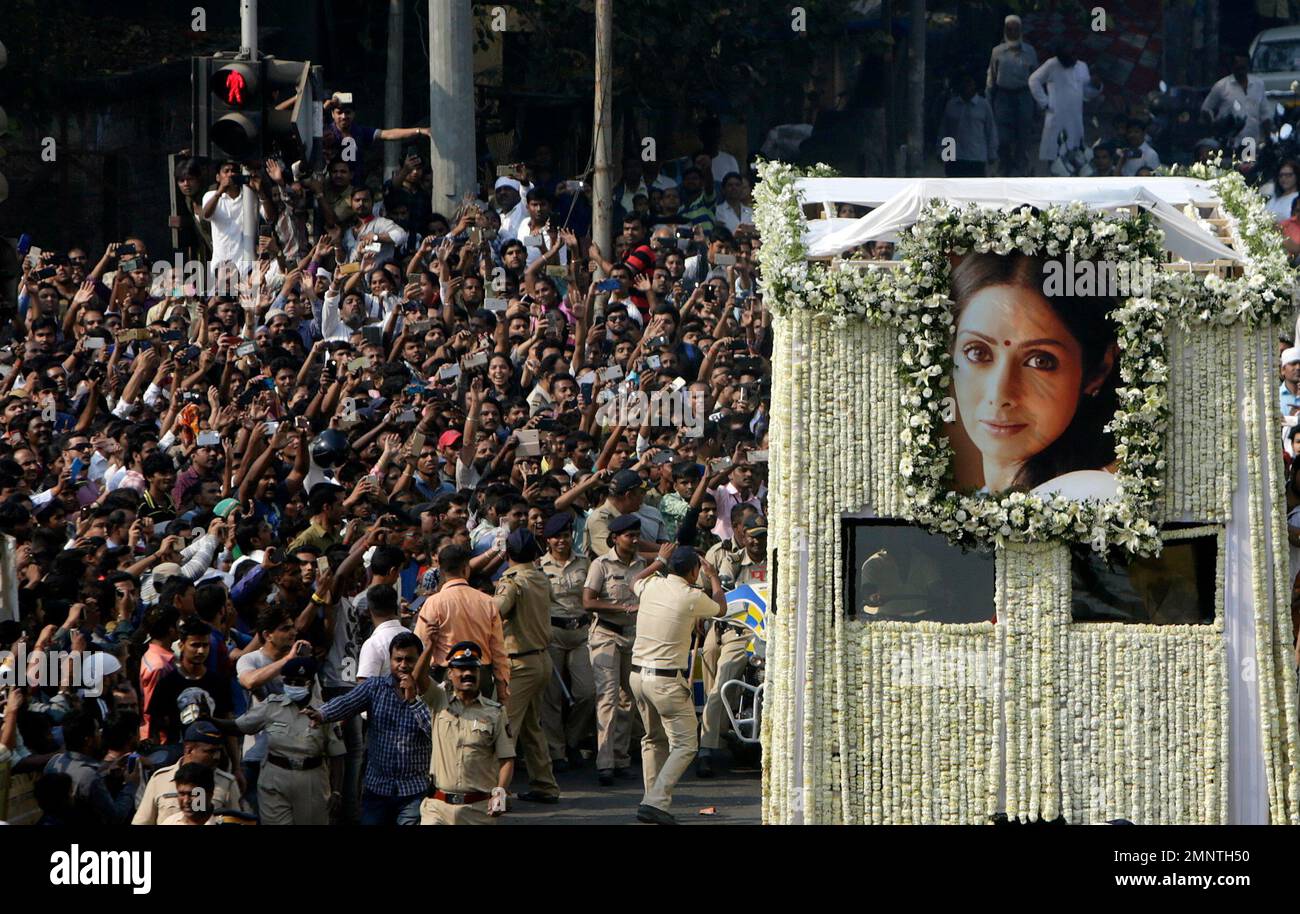 People take pictures on their mobile phones as the body of Indian
