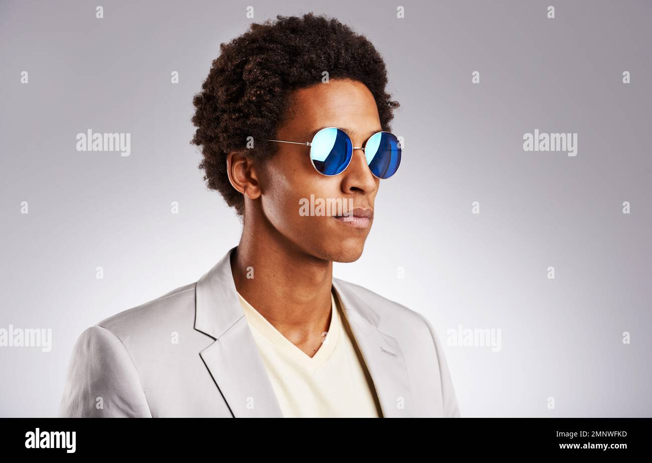 Regardez toujours le côté lumineux de la vie. Photo studio d'un jeune homme  portant des lunettes de soleil sur fond gris Photo Stock - Alamy
