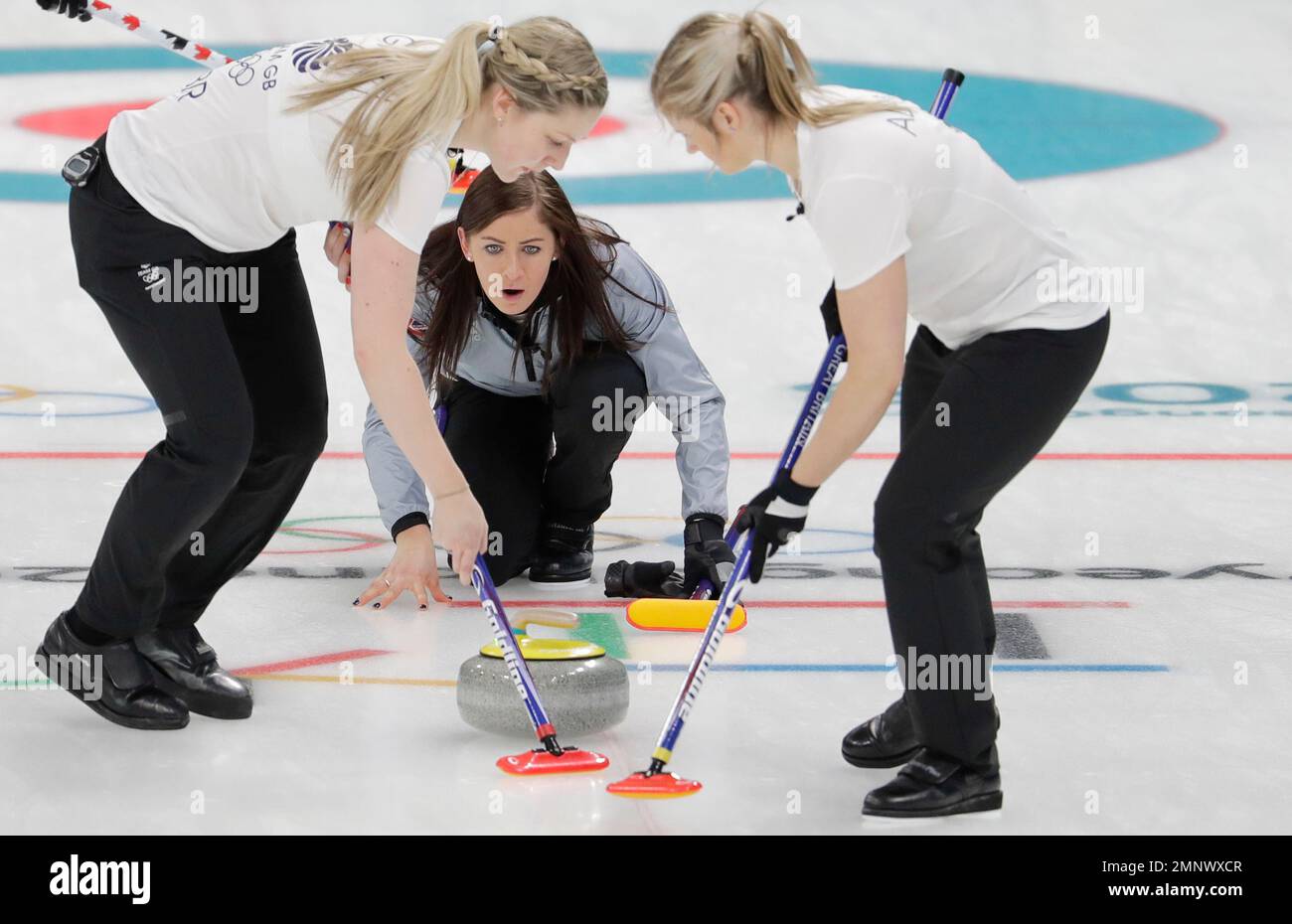 Britain's skip Eve Muirhead, center, throws a stone as teammates Lauren Gray, left, and Vicki Adams sweep the ice during a women's curling match against Canada at the 2018 Winter Olympics in Gangneung, South Korea, Wednesday, Feb. 21, 2018. (AP Photo/Natacha Pisarenko) Banque D'Images