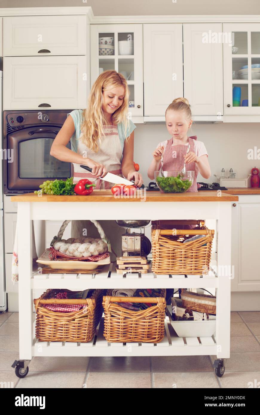 Faire un repas frais et sain. Une jeune mère et sa fille font une salade ensemble. Banque D'Images