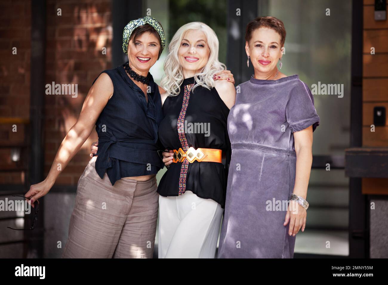 Les femmes matures se ruent et regardent la caméra dans la rue de la ville. Portrait d'amis heureux d'âge moyen à l'extérieur. Amitié féminine Banque D'Images