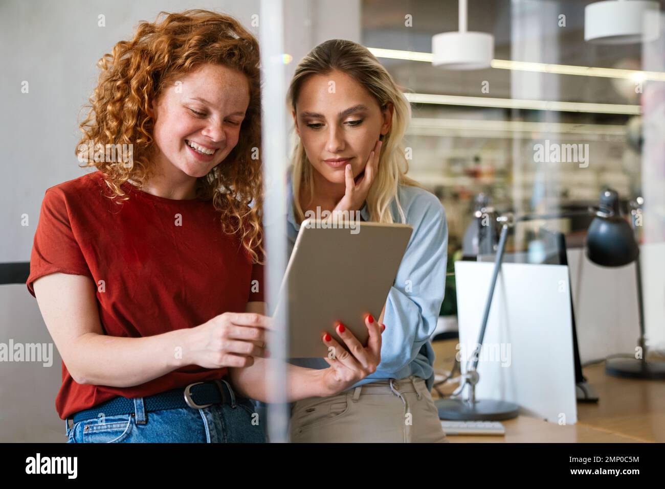 Portrait de jeunes femmes d'affaires heureuses, des designers souriant tout en travaillant ensemble au bureau Banque D'Images