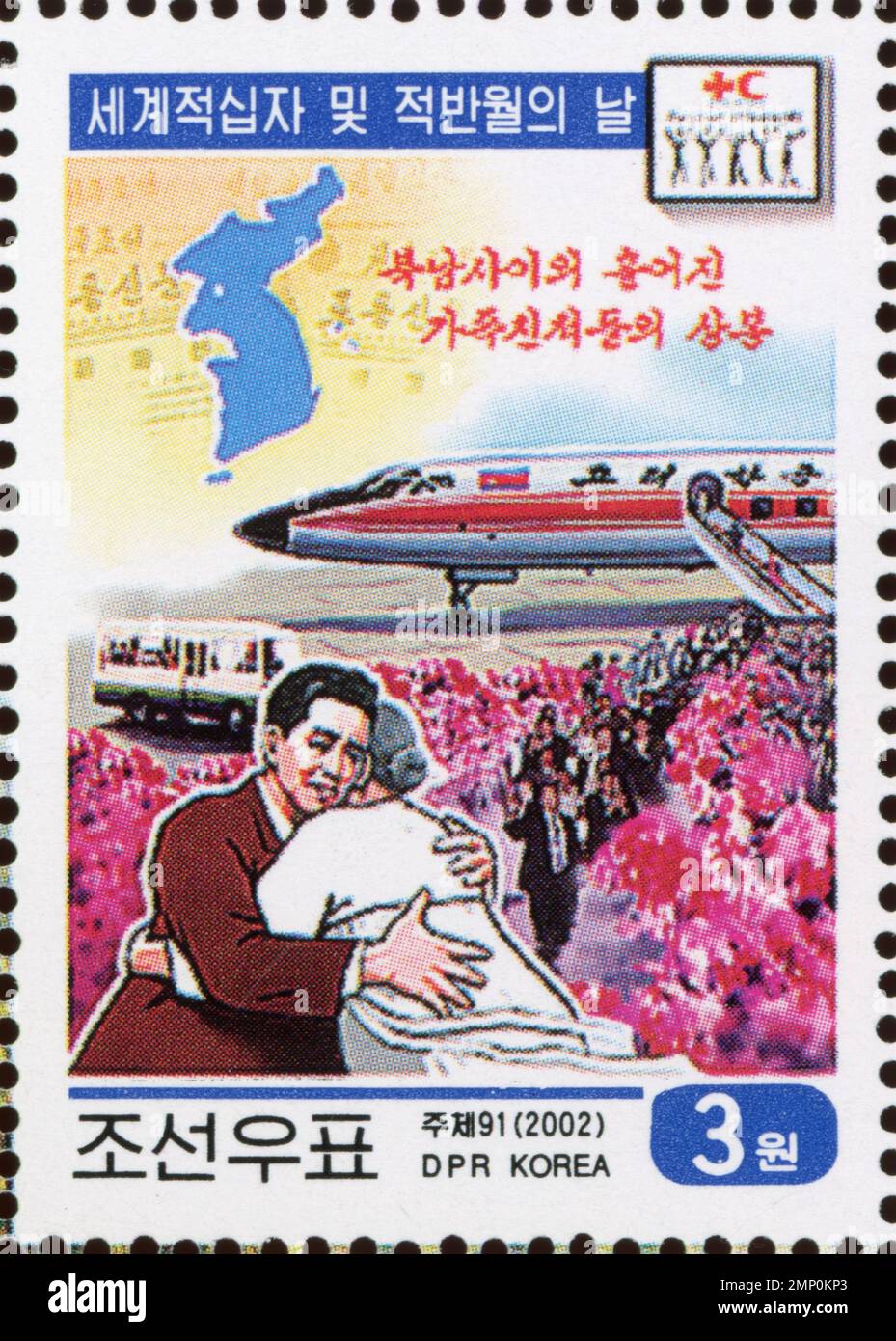 Timbre-poste nord-coréen de 2002 représentant une réunion de famille avec un avion Air Koryo et le logo de la Croix-Rouge. Banque D'Images