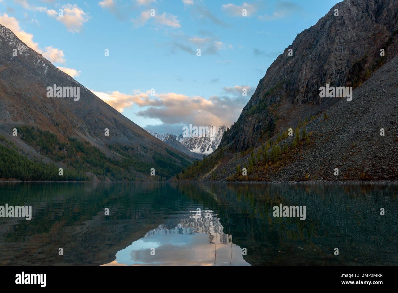 Lac de montagne Shavlinskoe entre les rochers avec des sommets enneigés ...