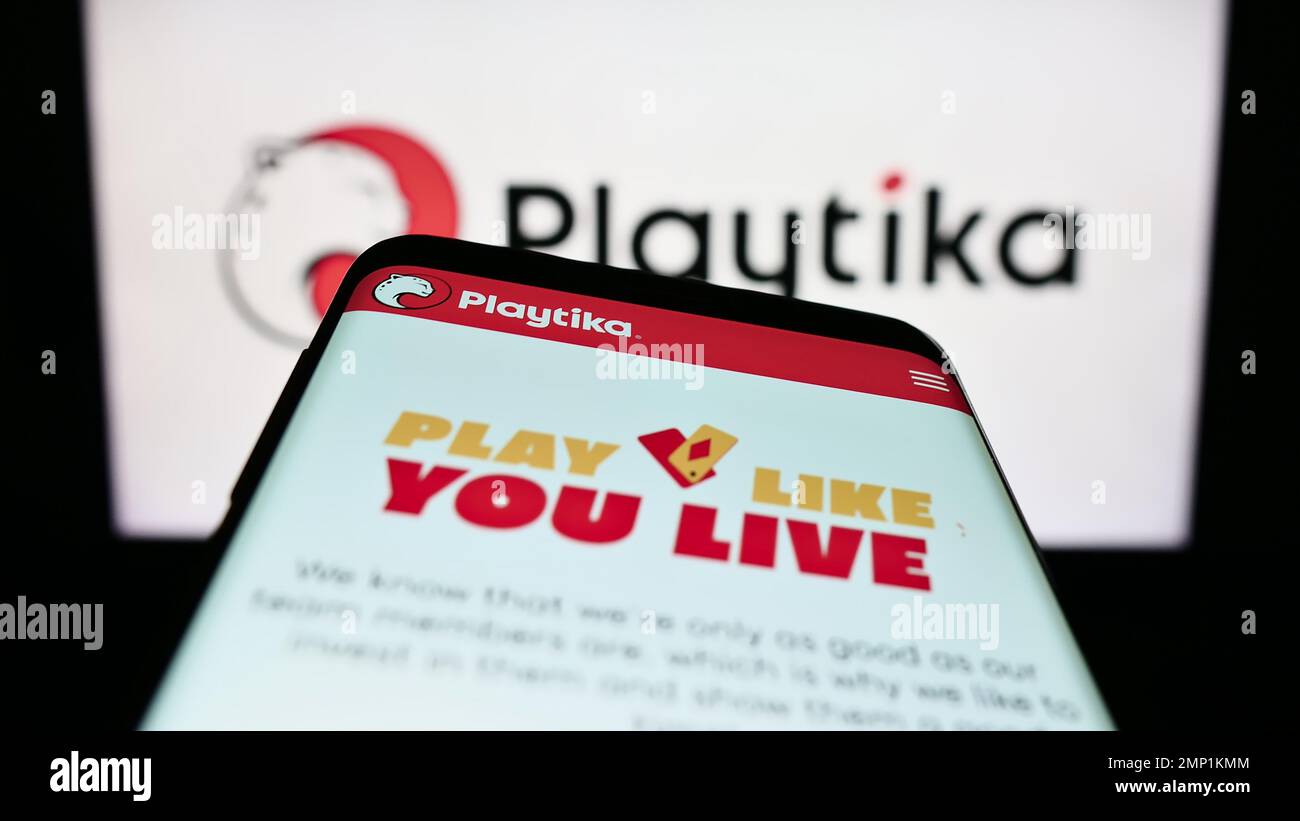 Smartphone avec le site Web de la société israélienne de jeux mobiles Playtika Ltd. À l'écran devant le logo d'entreprise. Faites la mise au point dans le coin supérieur gauche de l'écran du téléphone. Banque D'Images