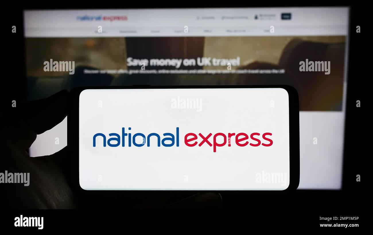 Personne tenant un téléphone portable avec le logo de la société britannique National Express Group plc (NX) à l'écran devant la page Web. Mise au point sur l'affichage du téléphone. Banque D'Images