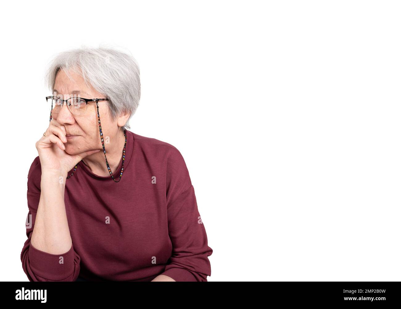 Femme âgée de 70s ans attentionnés et dépressive de race blanche. Problème de vieillesse dame âgée isolée sur blanc, espace de copie. S'ennuyer, souffrant de perte de mémoire. Banque D'Images