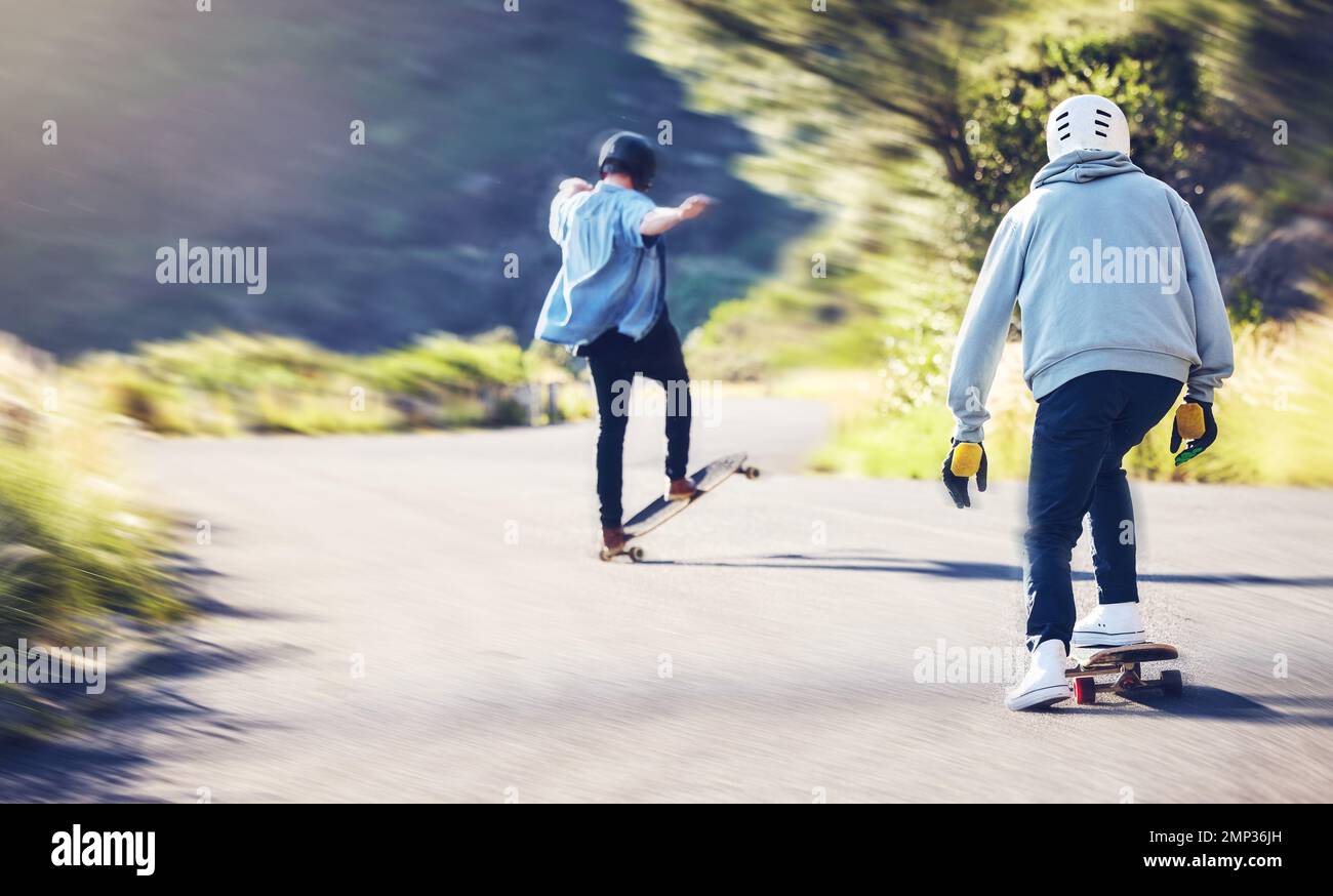 Amis, vitesse et patinage de longue durée sur route, hommes course en descente avec skateboard et casque pour la sécurité. Aventure sportive extrême, skateboard Banque D'Images