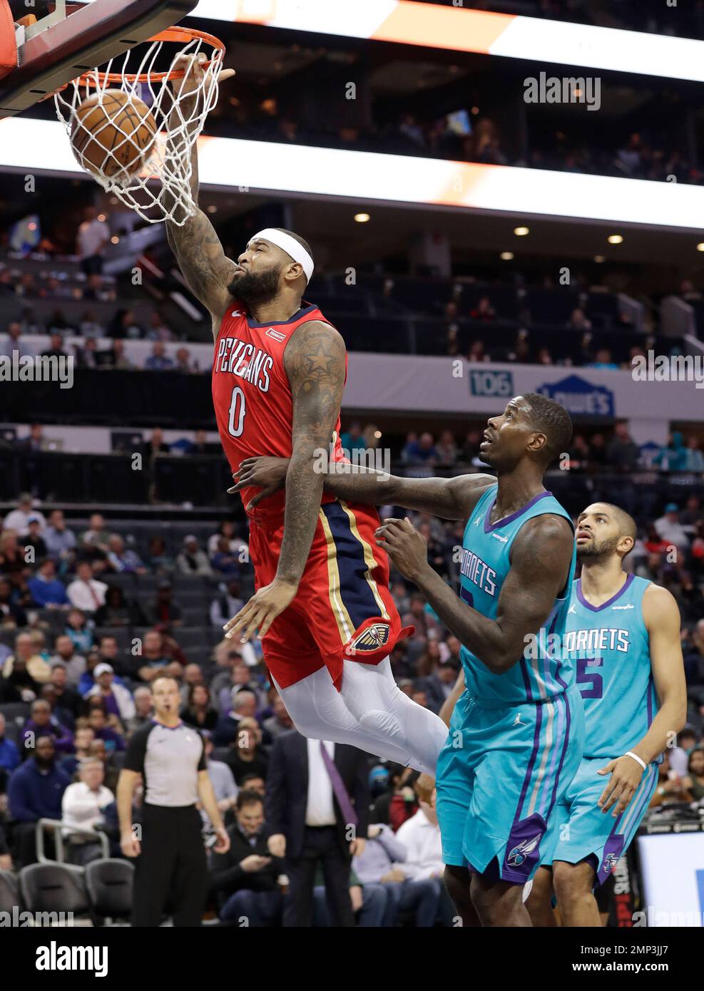 New Orleans Pelicans' DeMarcus Cousins (0) dunks past Charlotte Hornets' Nicolas Batum (5) and Marvin Williams (2) during the second half of an NBA basketball game in Charlotte, N.C., Wednesday, Jan. 24, 2018. (AP Photo/Chuck Burton) Banque D'Images