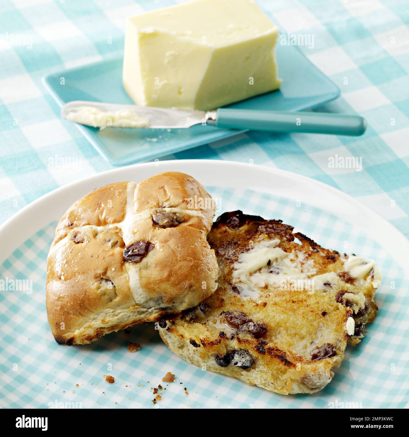 pain croisé chaud beurré tranché ouvert grillé pâques traditionnel tissu de table vichy couteau de cuisine beurre fondre délicieux blé de saison cuit au sol Banque D'Images pain croisé chaud beurré tranché ouvert grillé pâques traditionnel tissu de table vichy couteau de cuisine beurre fondre délicieux blé de saison cuit au sol Banque D'Images