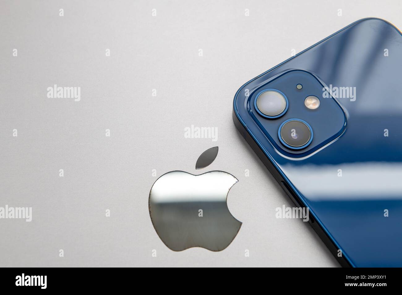 Londres. ROYAUME-UNI- 01.29.2023. L'icône de la société Apple à l'arrière d'un MacBook avec un iPhone en haut. Banque D'Images