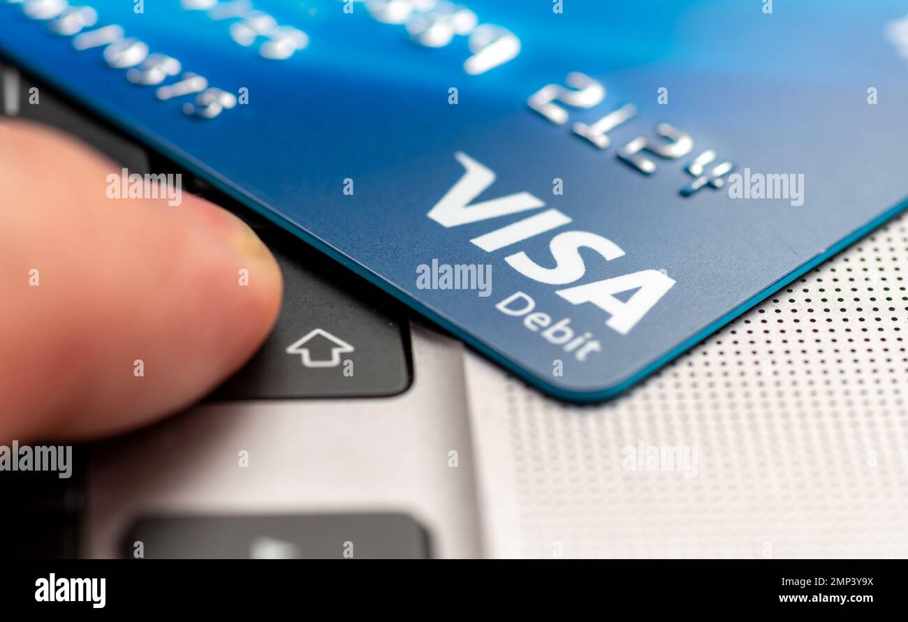 Londres. ROYAUME-UNI- 01.29.2023. Une carte de débit Visa sur un ordinateur portable avec une personne qui appuie sur le bouton ENTER. Banque D'Images