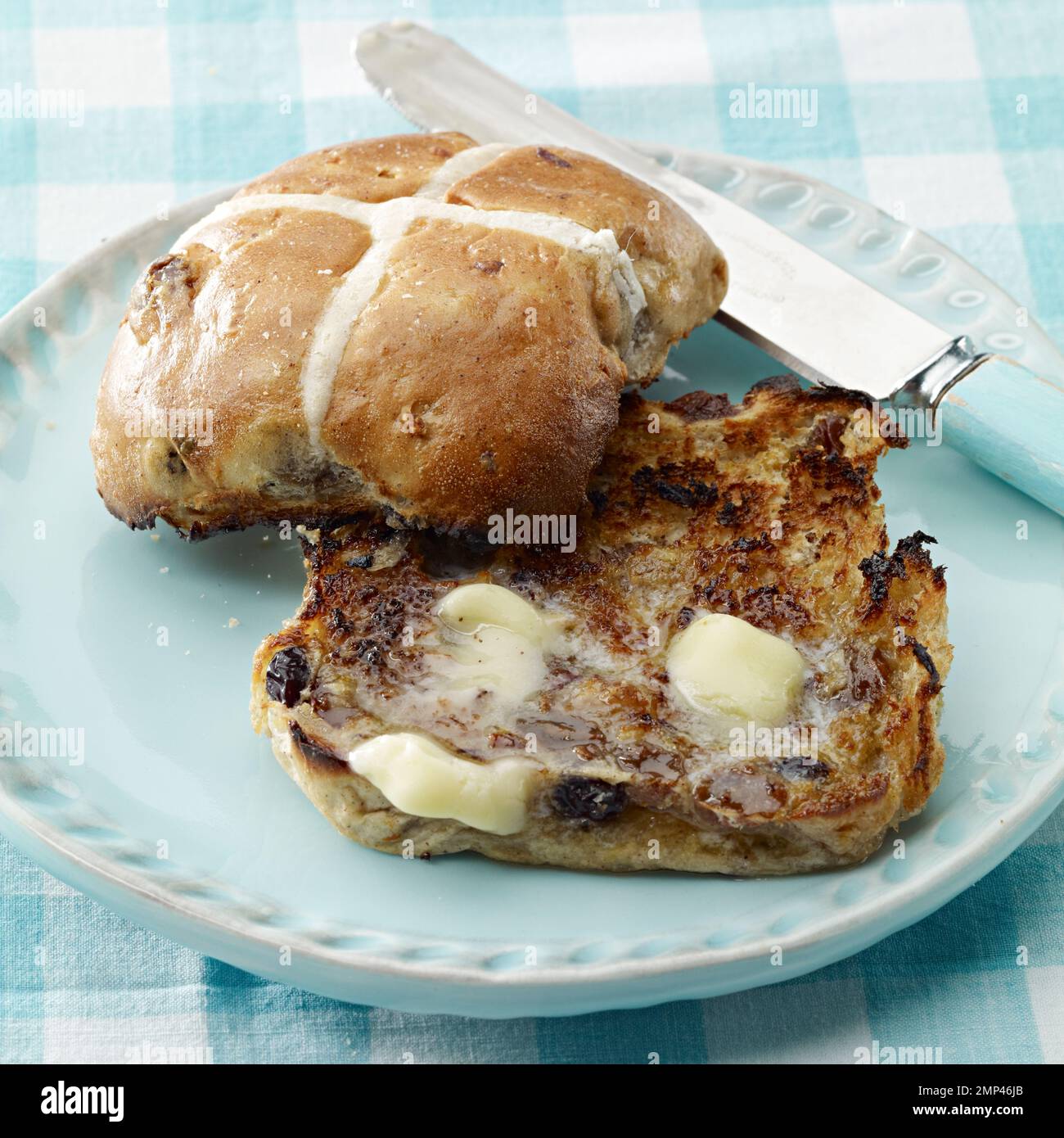 pain croisé chaud beurré tranché ouvert grillé pâques traditionnel tissu de table vichy couteau de cuisine beurre fondre délicieux blé de saison cuit au sol Banque D'Images pain croisé chaud beurré tranché ouvert grillé pâques traditionnel tissu de table vichy couteau de cuisine beurre fondre délicieux blé de saison cuit au sol Banque D'Images
