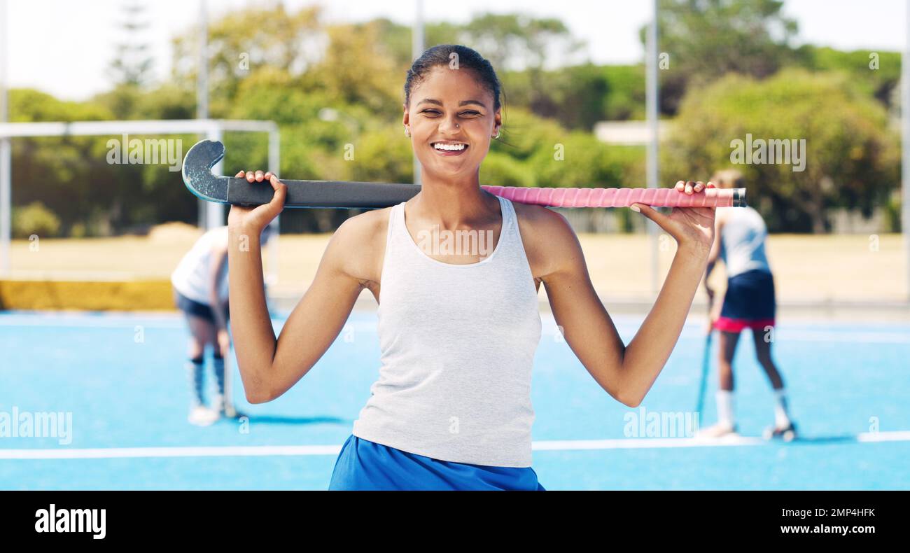 Fille indienne, athlète de l'équipe de hockey et portrait d'un joueur de sport sur le terrain. Heureux, sourire et soleil avec une femme de sport prête pour le jeu Banque D'Images