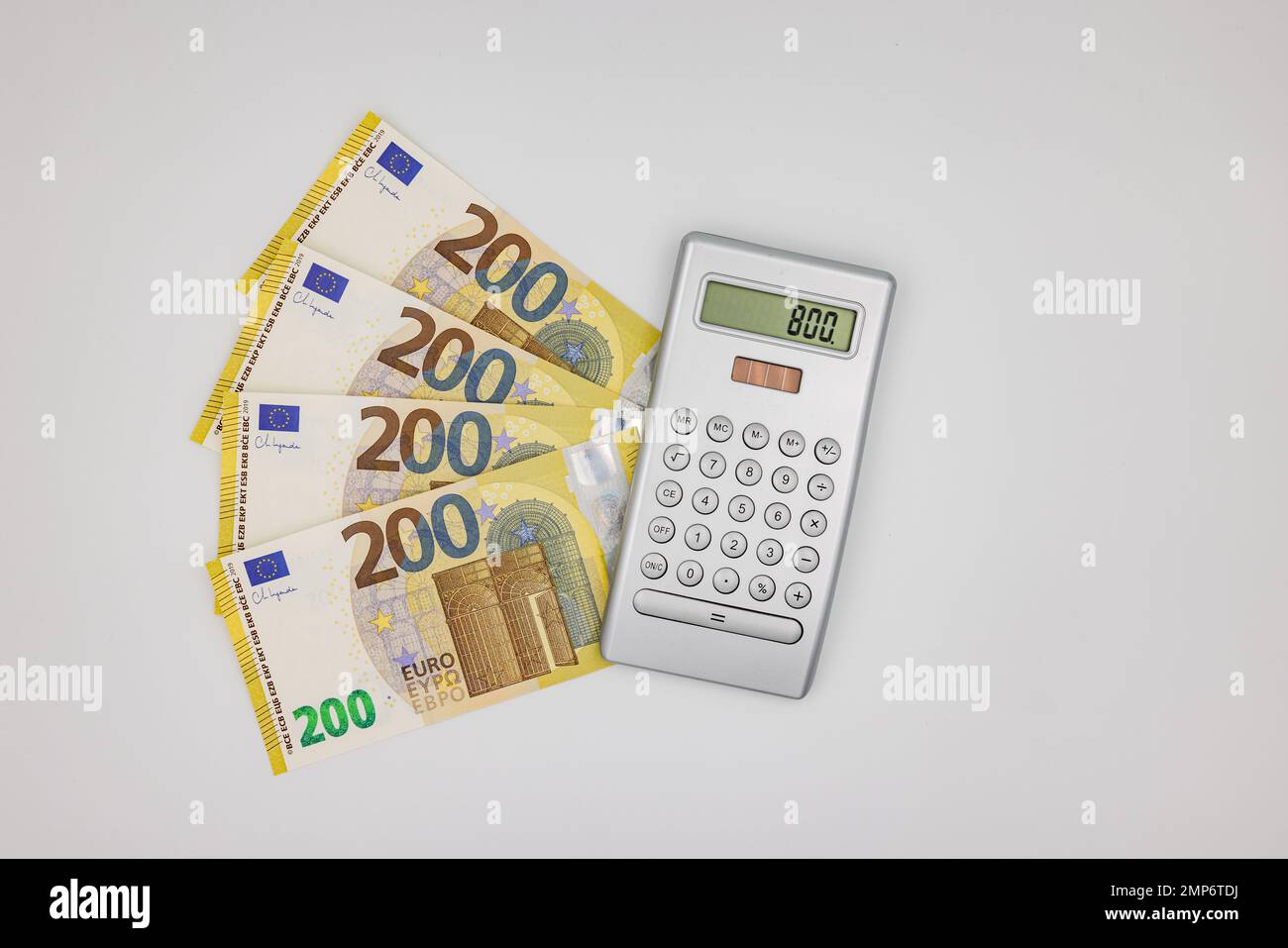 Plusieurs billets de 200 euros à côté d'une calculatrice sur fond blanc comme une photo de studio Banque D'Images