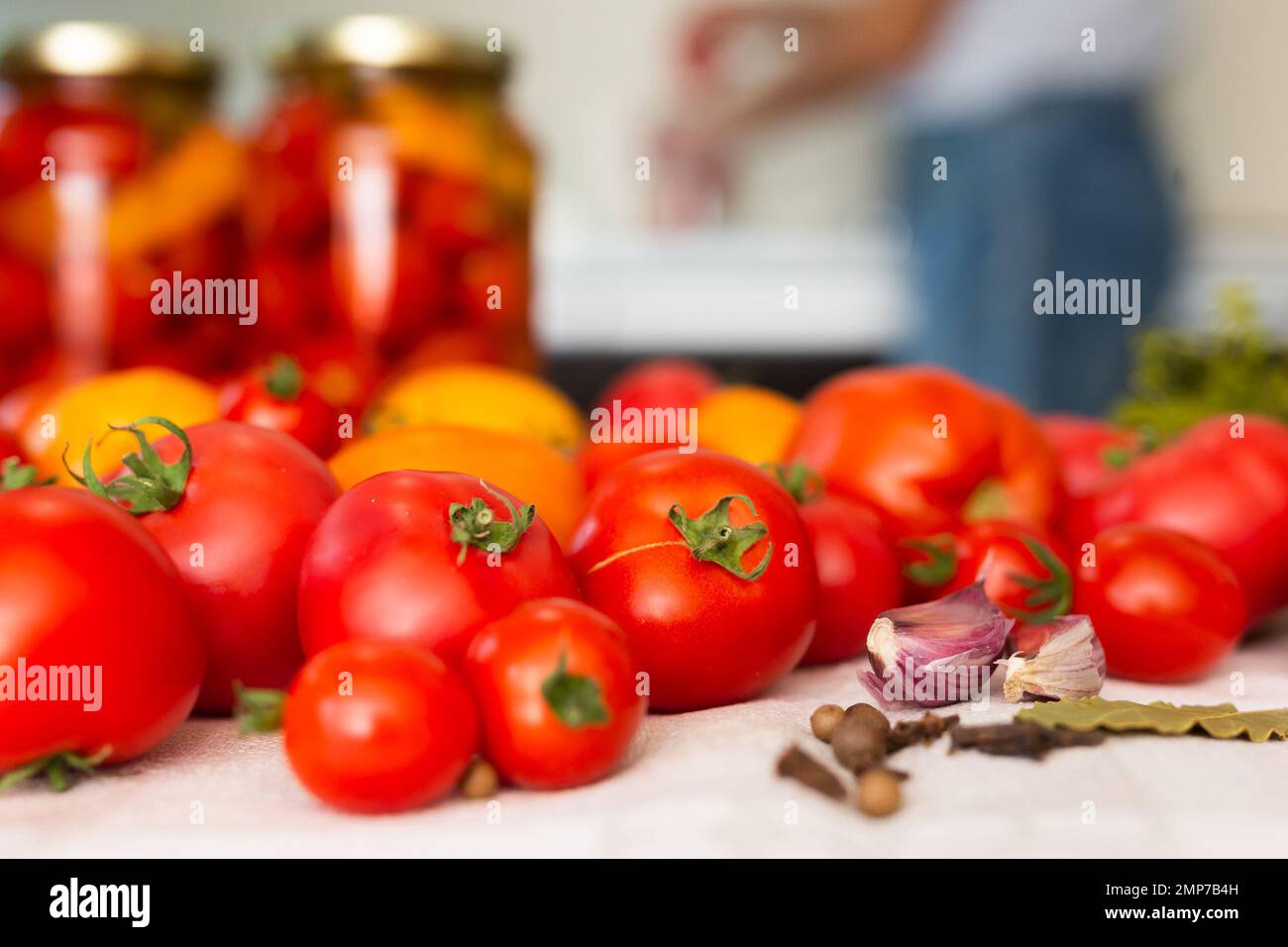 tomates rouges fraîches, épices, assaisonnements et tomates marinées en pots sur la table Banque D'Images