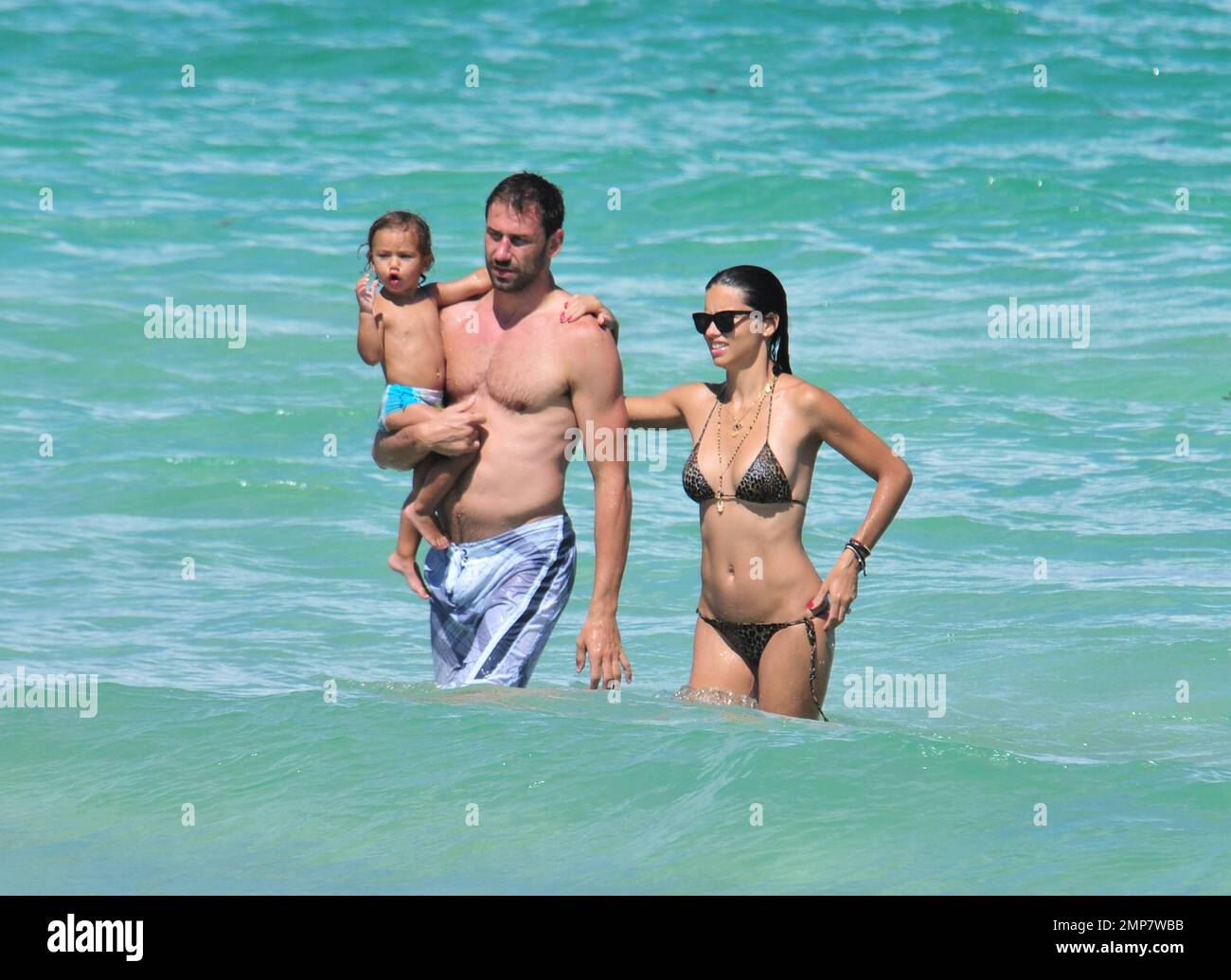 Adriana Lima, la fille Valentina et le mari Marko Jaric s'amusent dans le surf sur Miami Beach, FL, 31st juillet 2011. Banque D'Images