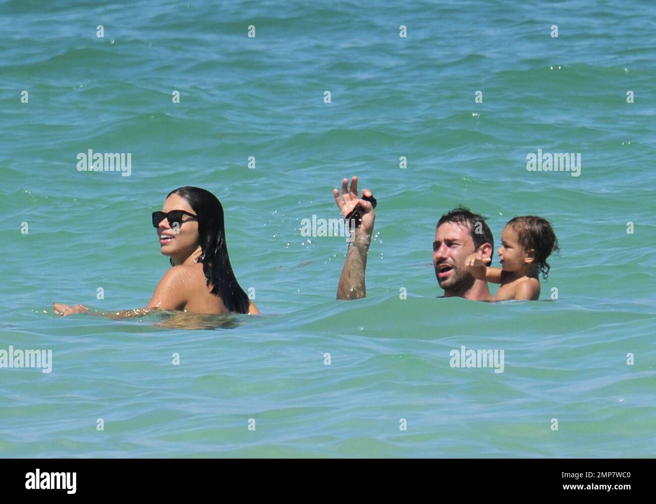 Adriana Lima, la fille Valentina et le mari Marko Jaric s'amusent dans le surf sur Miami Beach, FL, 31st juillet 2011. Banque D'Images