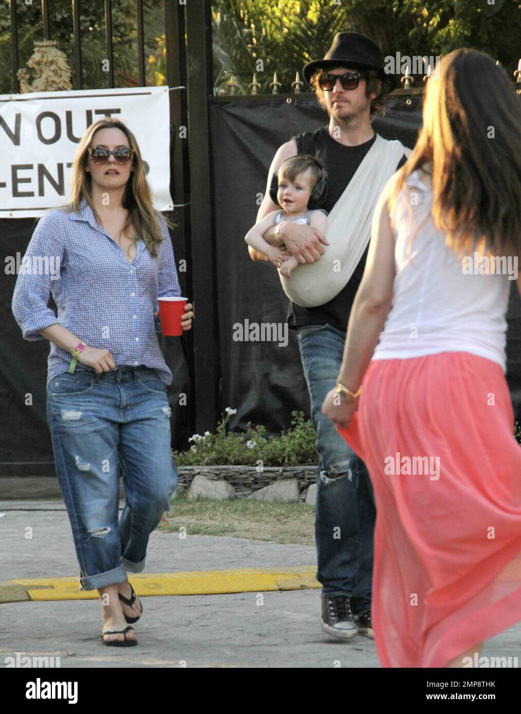 L'actrice Alicia Silverston ainsi que son mari Christopher Jarecki et son fils de 11 mois Bear Blu ont été repérés au Festival de musique Coachella 2012. Alicia portait un haut bleu avec un Jean bleu roulé et des tongs tandis que Christopher portait leur fils dans une élingue pour bébé. L'élégant Bear Blu a été vu porter des écouteurs. Indio, Californie 21st avril 2012. Banque D'Images