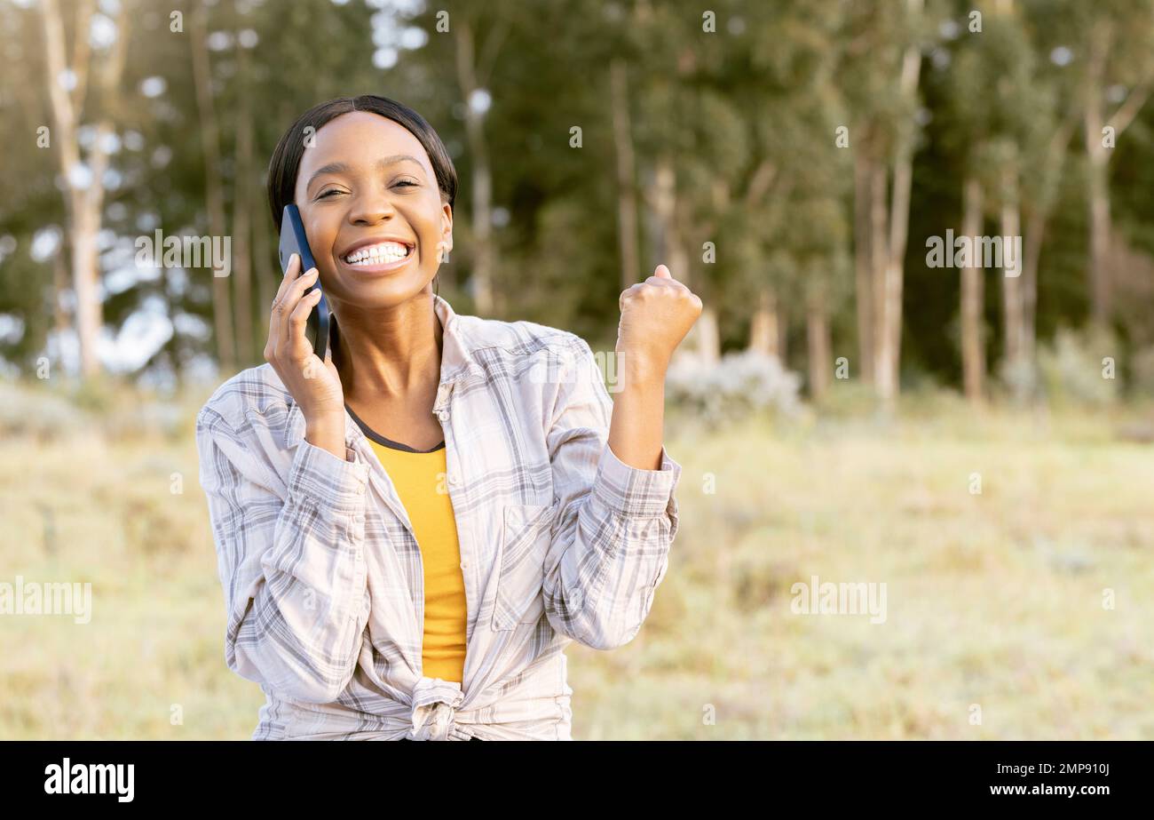 Femme gagnante, réussie et noire sur un appel téléphonique dans la nature, heureuse et excitée par la réalisation. Gagnant, communication et fille africaine à l'écoute sur un Banque D'Images