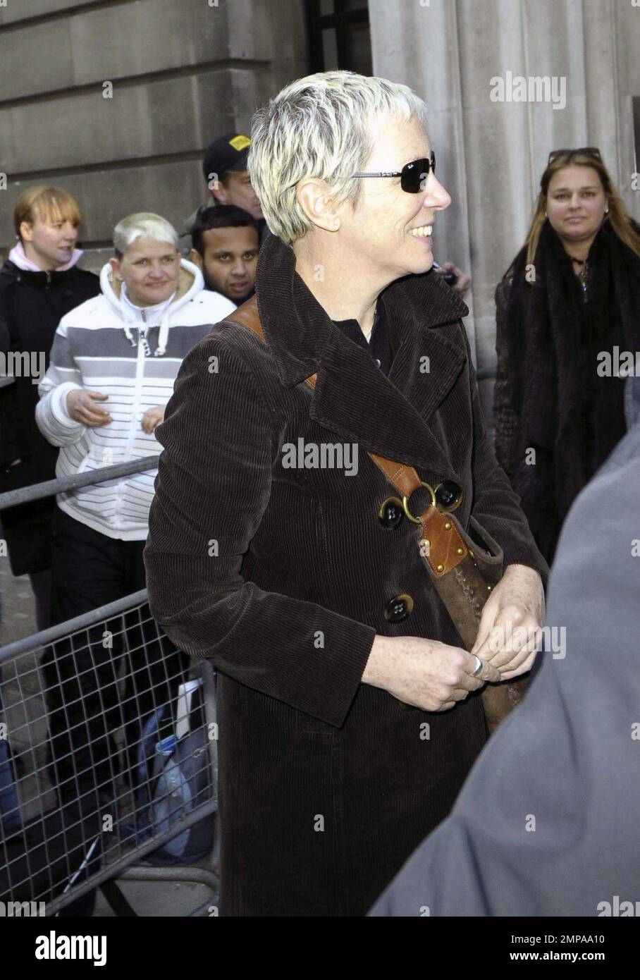 La rocker et ancienne chanteuse Eurythmics Annie Lennox porte un manteau noir avec un pantalon gris et porte un sac à main en daim marron alors qu'elle quitte BBC radio 2. Lennox était tout sourire alors qu'elle bavardait avec les fans sur son chemin. Londres, Royaume-Uni. 3/4/11. Banque D'Images