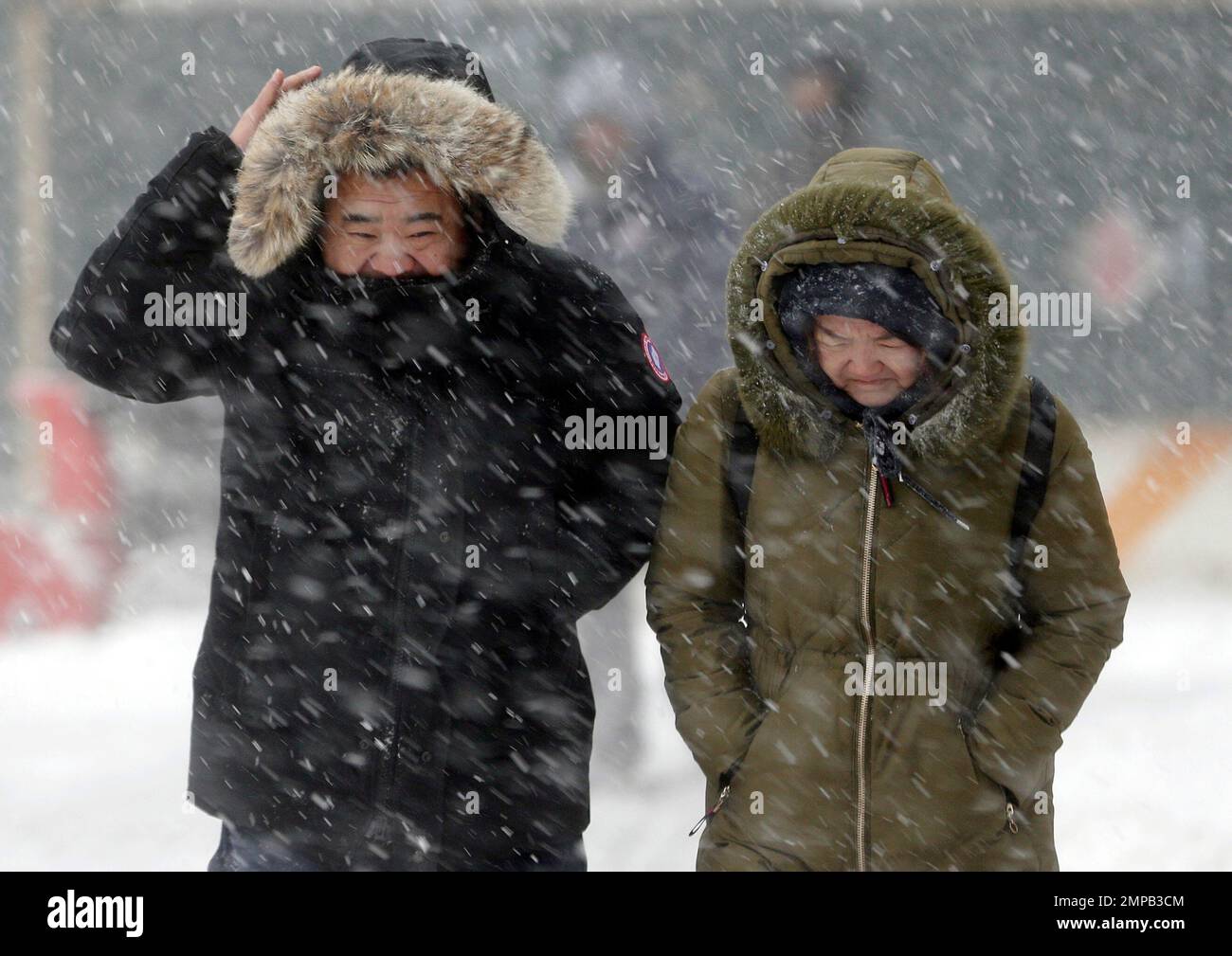 Pedestrians try to shield themselves as a strong wind blows snow in their faces in New York, Thursday, Jan. 4, 2018. Residents across a huge swath of the U.S. awakened Thursday to the beginnings of a massive winter storm expected to deliver snow, ice and high winds followed by possible record-breaking cold as it moves up the Eastern Seaboard from the Carolinas to Maine. (AP Photo/Seth Wenig) Banque D'Images