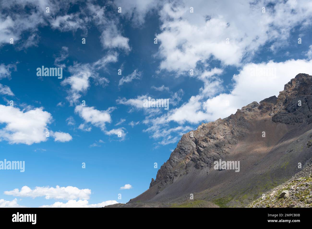Roche en pierre pendant la journée sur fond de nuages blancs. Banque D'Images
