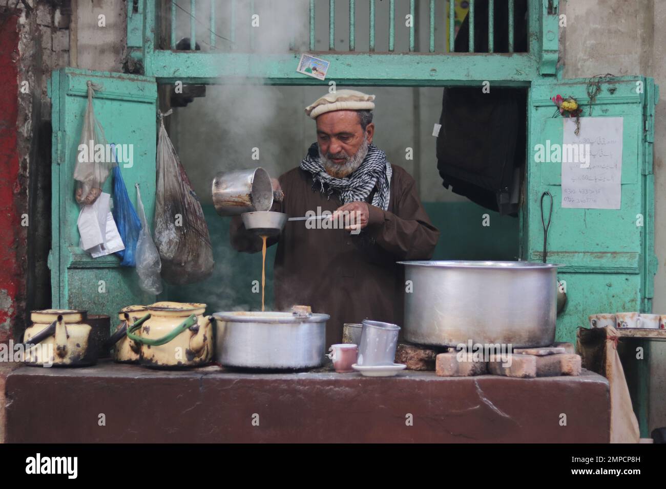 Boutique traditionnelle de chai dans le Pkaistan, Un homme faisant du thé Banque D'Images