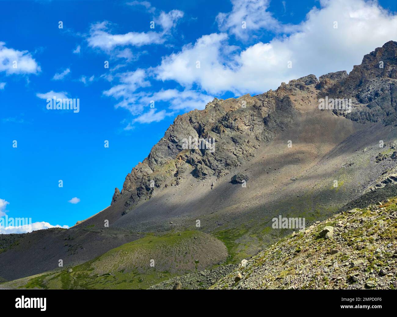 Roche en pierre pendant la journée sur fond de nuages blancs avec de l'herbe verte en Altaï. Banque D'Images