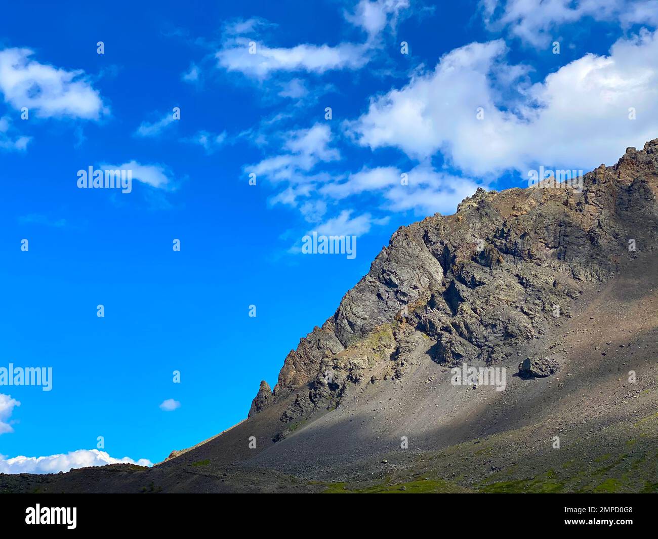 Roche en pierre pendant la journée sur fond de nuages blancs avec de l'herbe verte en Altaï. Banque D'Images