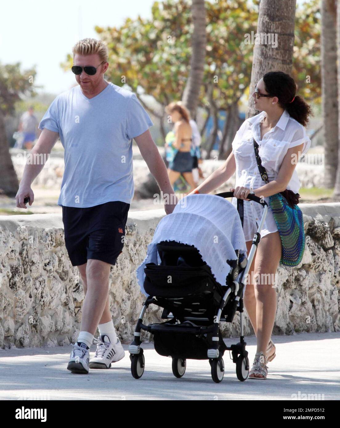 Boris Becker, un joueur de tennis, marche le long de la promenade de Miami  Beach, bâchant et tenant la main avec sa femme Sharlely et son bébé Amadeus  de six semaines dans