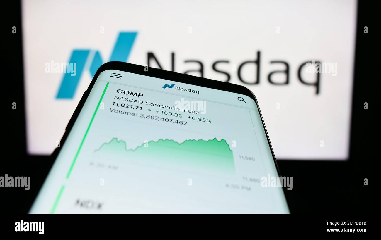 Smartphone avec le site web de la bourse américaine Nasdaq sur l'écran devant le logo de l'entreprise. Faites la mise au point dans le coin supérieur gauche de l'écran du téléphone. Banque D'Images