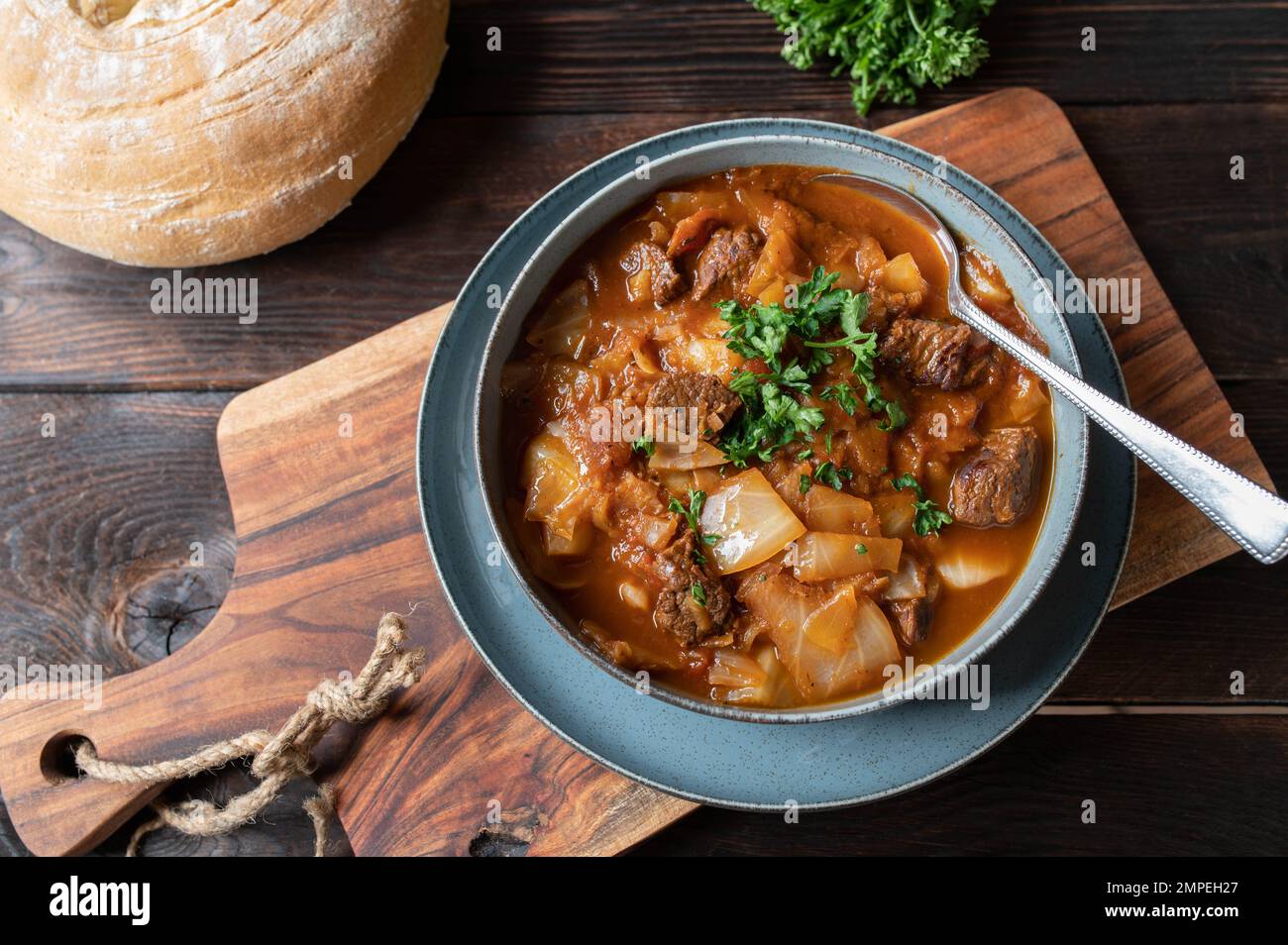 Ragoût de boeuf brun avec chou et légumes. Servi avec du pain ciabatta maison sur une table en bois Banque D'Images