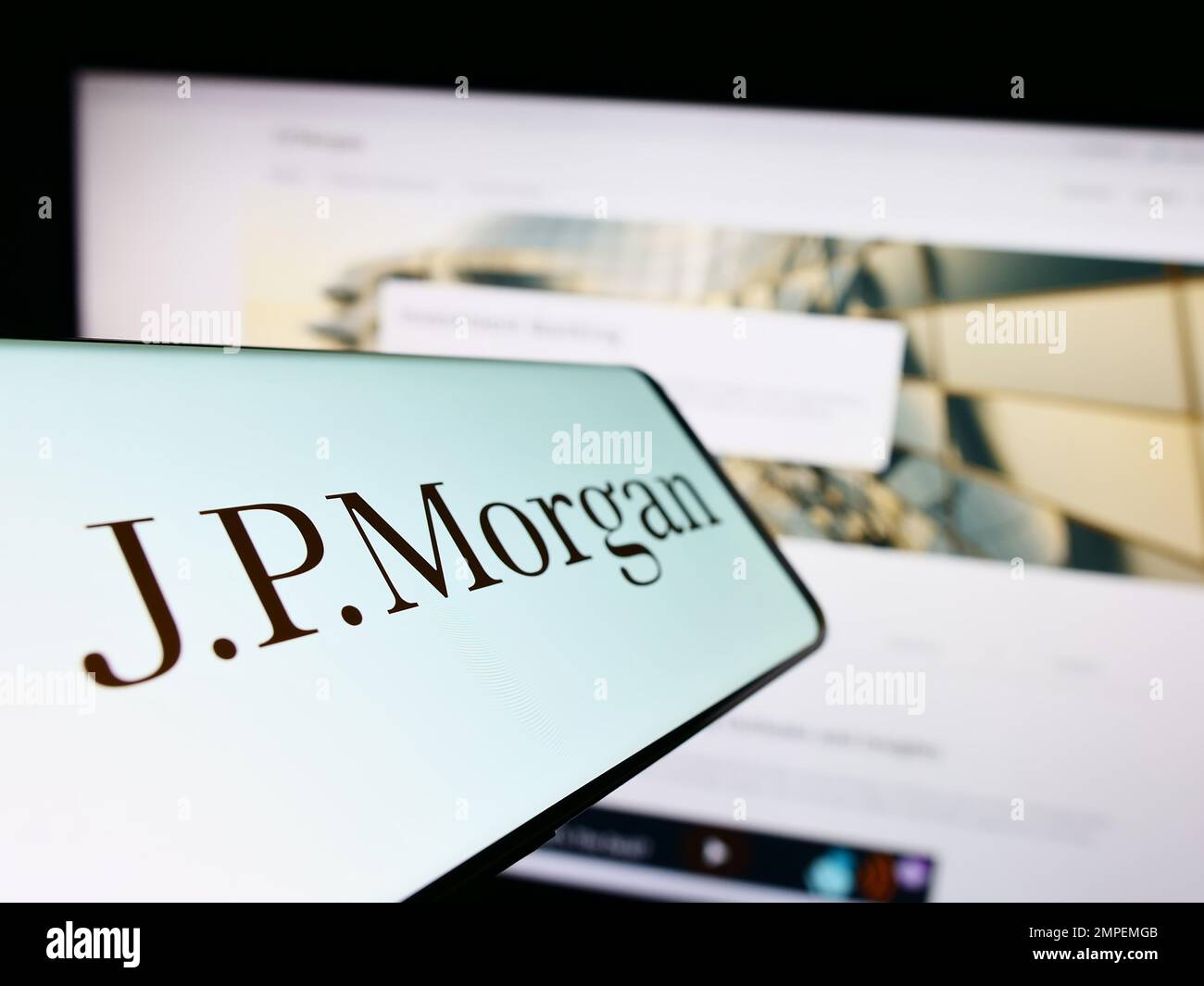 Téléphone portable avec logo de la société américaine de services financiers J.P. Morgan Co. À l'écran devant le site Web. Mise au point au centre-gauche de l'écran du téléphone. Banque D'Images