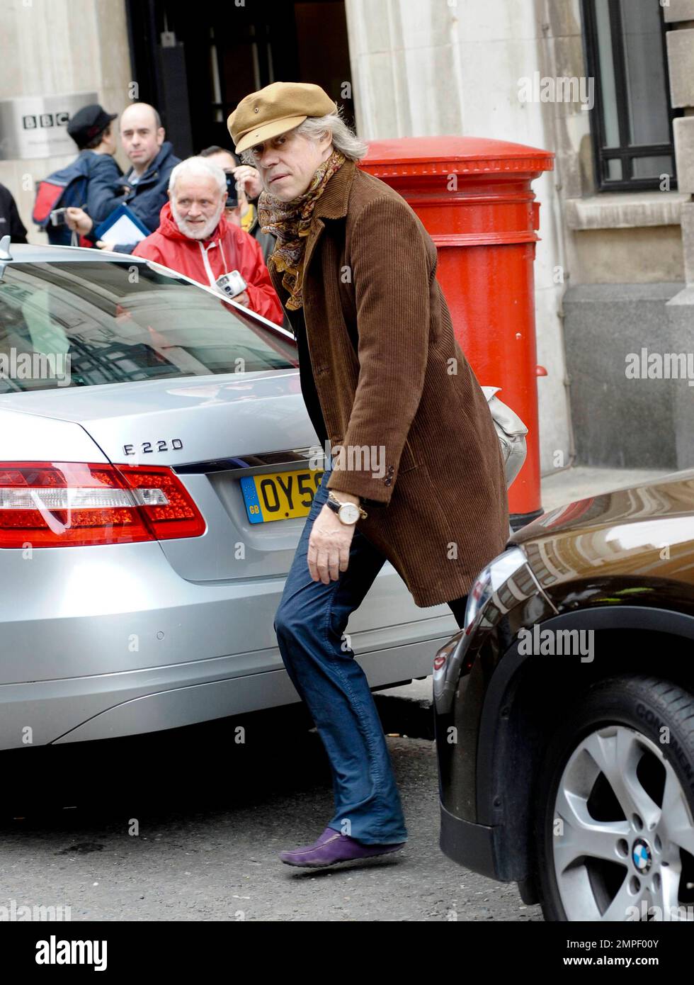 Le chanteur et activiste Bob Geldof porte une casquette de conducteur et  des mocassins en daim violet à BBC radio 2. Geldof a gardé un visage droit  lorsqu'il a quitté les studios