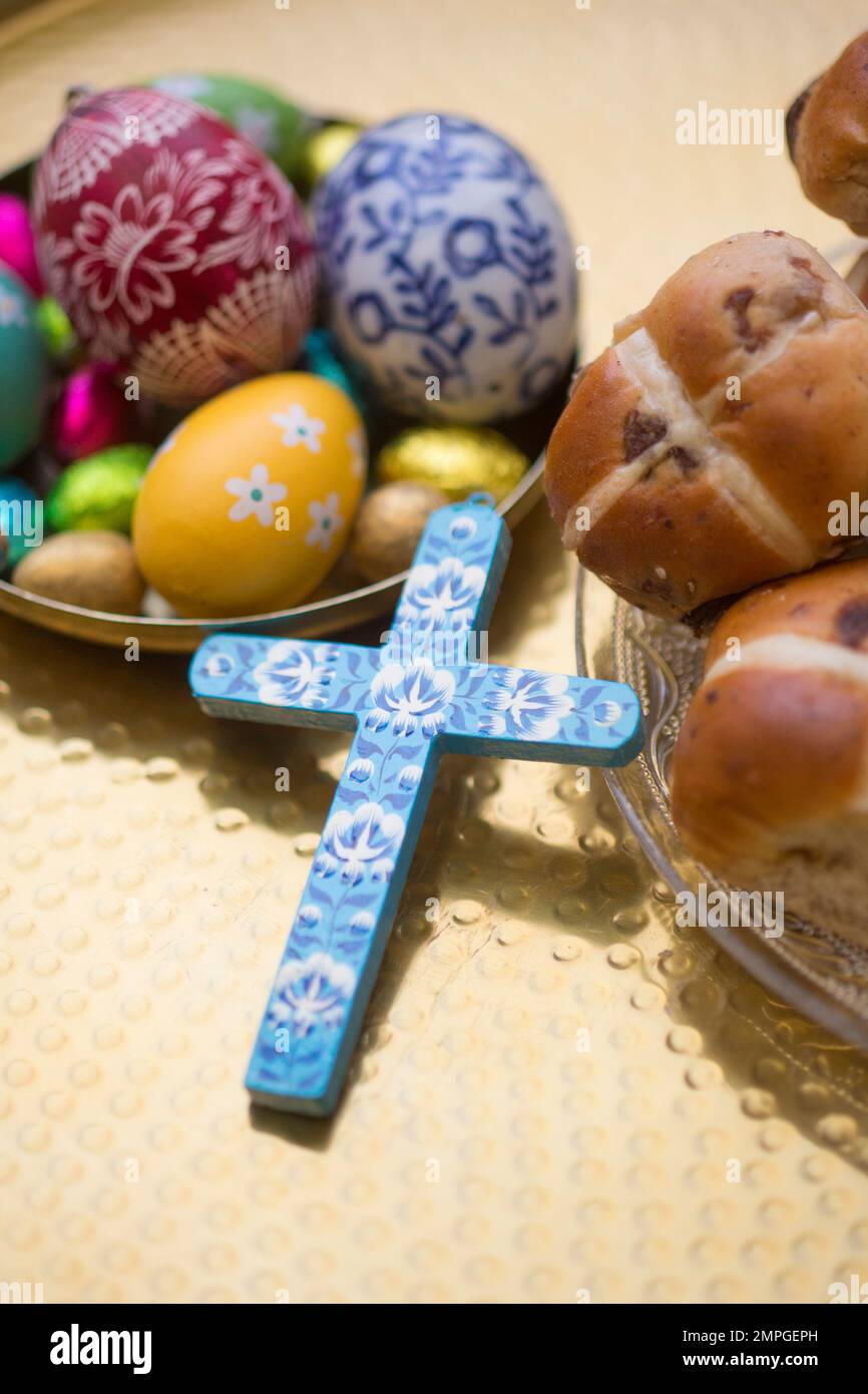 Table de Pâques avec petits pains à croix chaude, œufs décorés et croix Banque D'Images