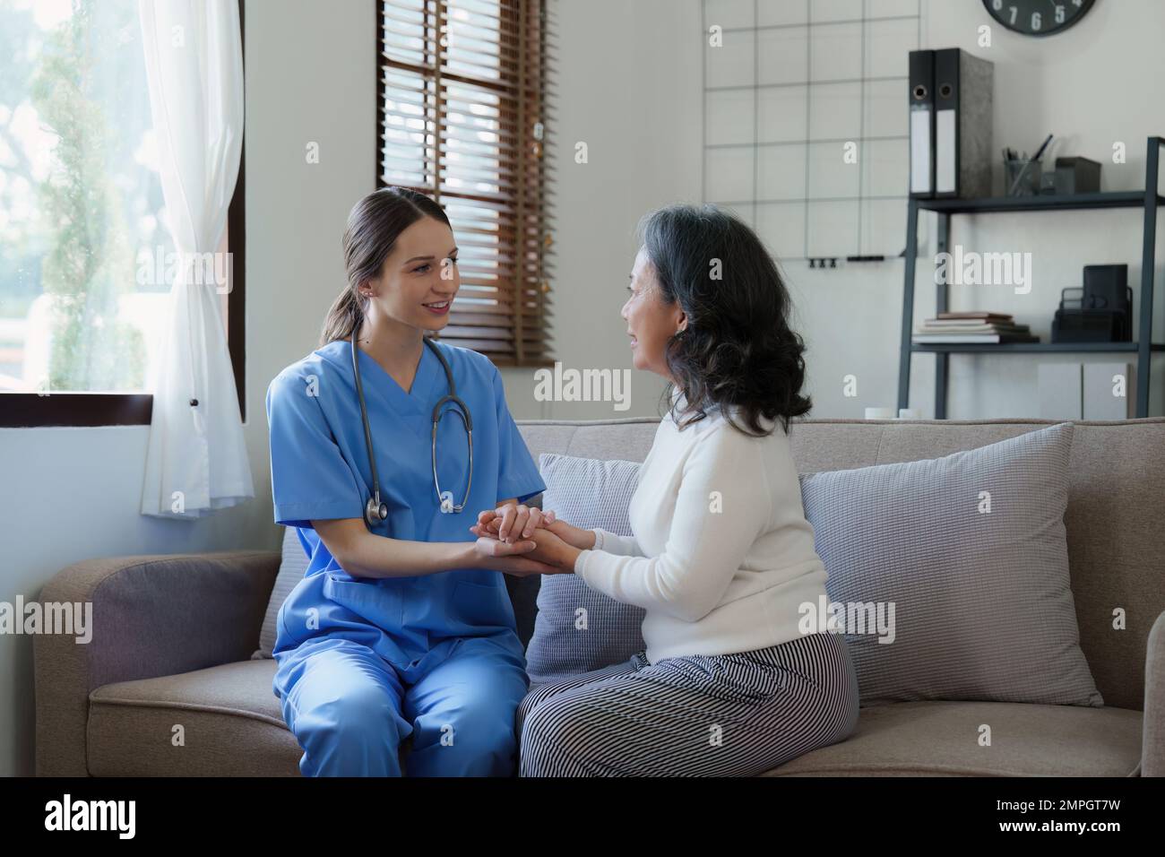 Infirmière de soins à domicile, physiothérapie avec une femme adulte senior à la maison Banque D'Images